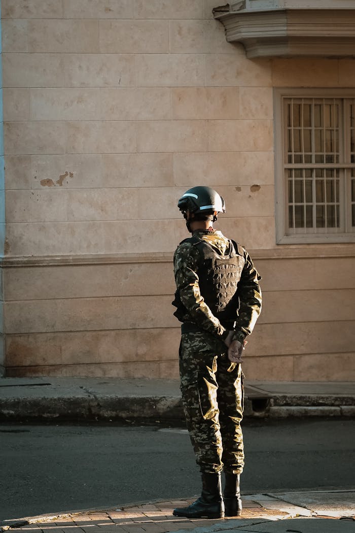 A soldier in uniform stands guard in a city street, illustrating urban security in Colombia.