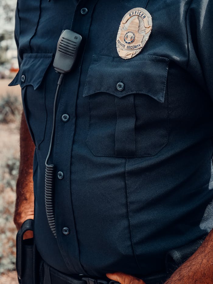 Detailed view of a police officer's uniform showcasing the badge and radio equipment.